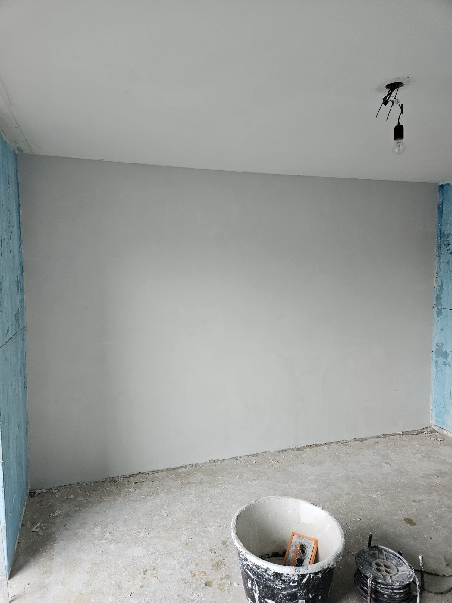 Strak glad stucwerk op wand en plafond door Wijnans, stukadoor in Breda